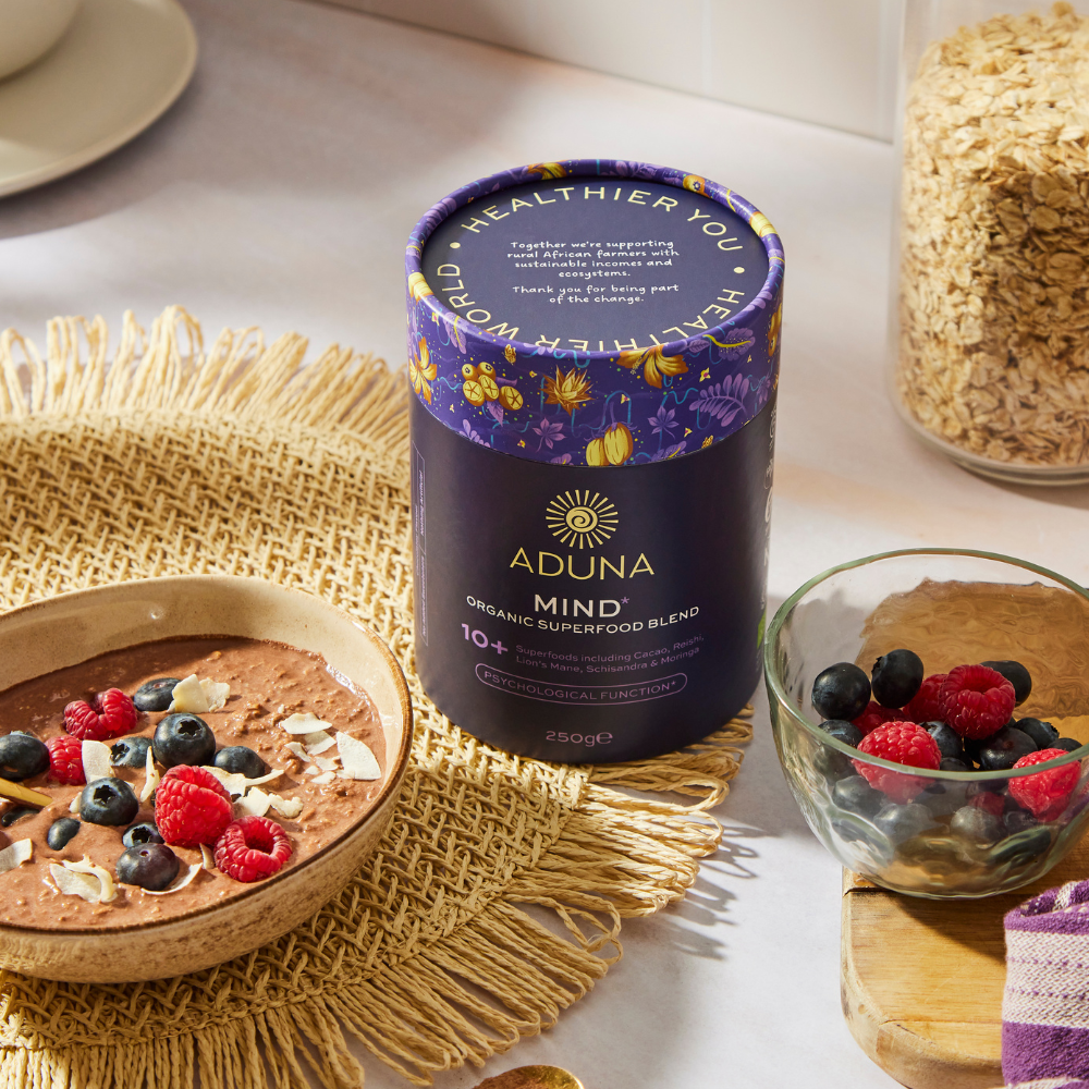 Package of Aduna Mind Organic Superfood Blend 250g with a bowl of berries either side