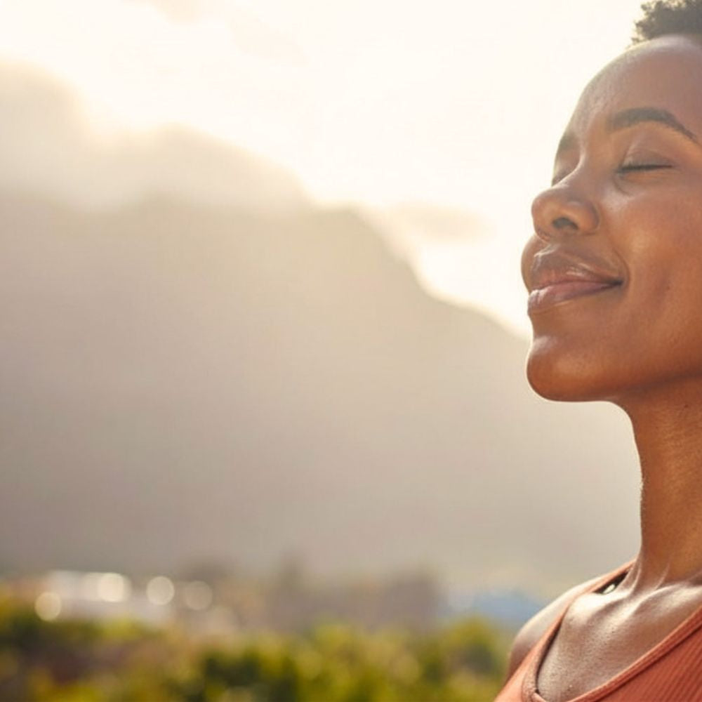 Woman with eyes closed, smiling, practicing mental focus.