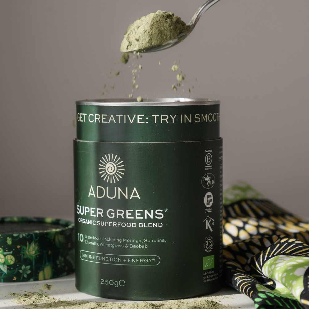 Spoonful lifting out of a package of Aduna Super Greens Organic Superfood Blend