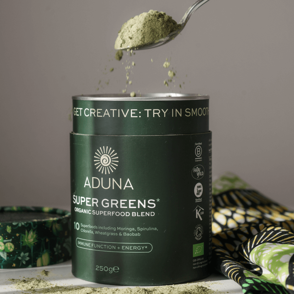 Spoonful lifting out of a package of Aduna Super Greens Organic Superfood Blend