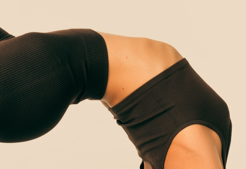 Crop of woman's stomach in a yoga position