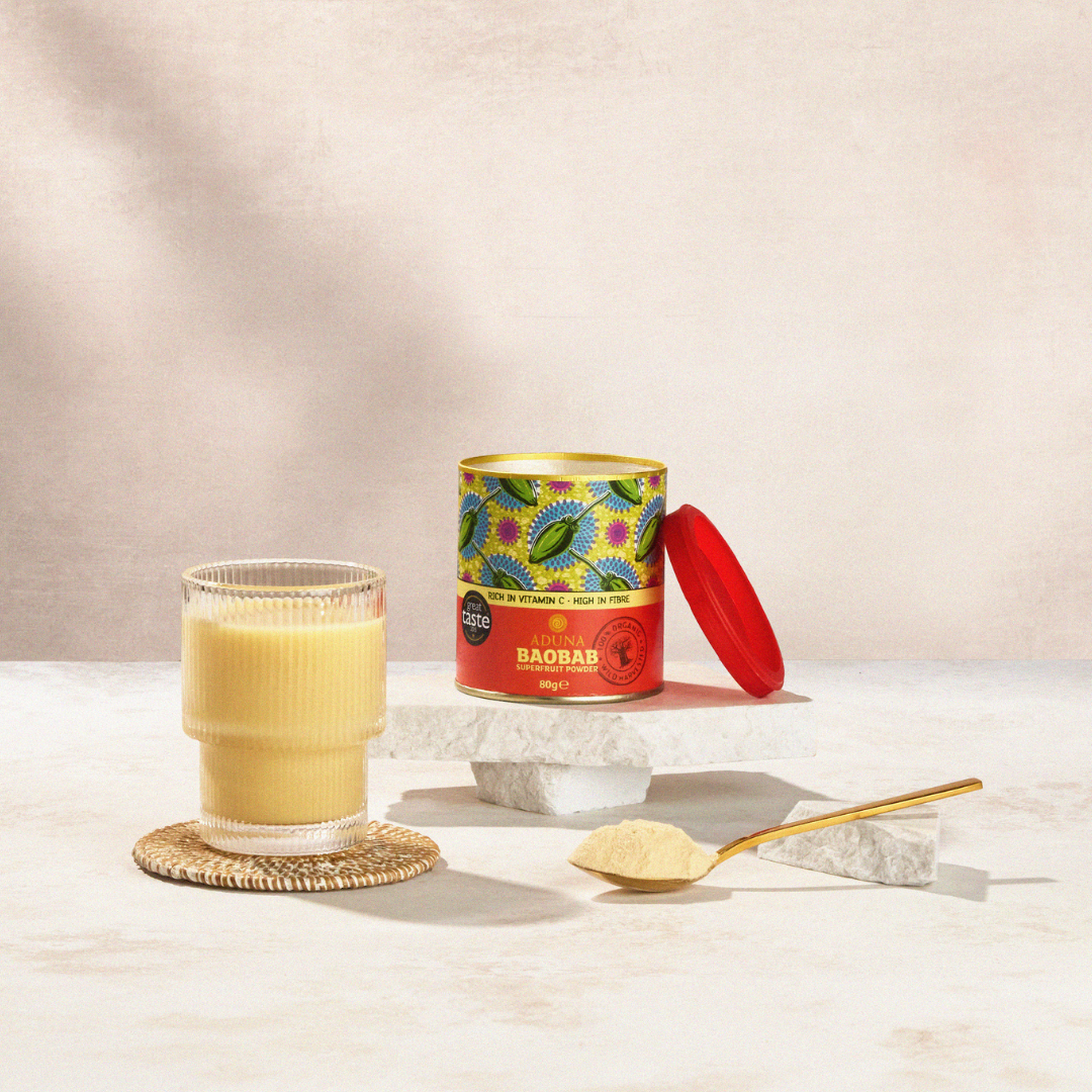 Aduna Baobab Tub with a yellow smoothie and spoon of baobab powder on a marble surface